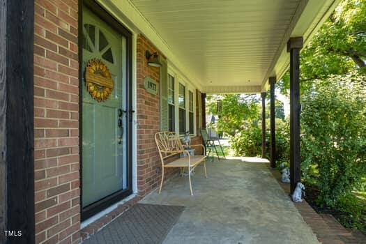 a view of a porch with chairs and backyard