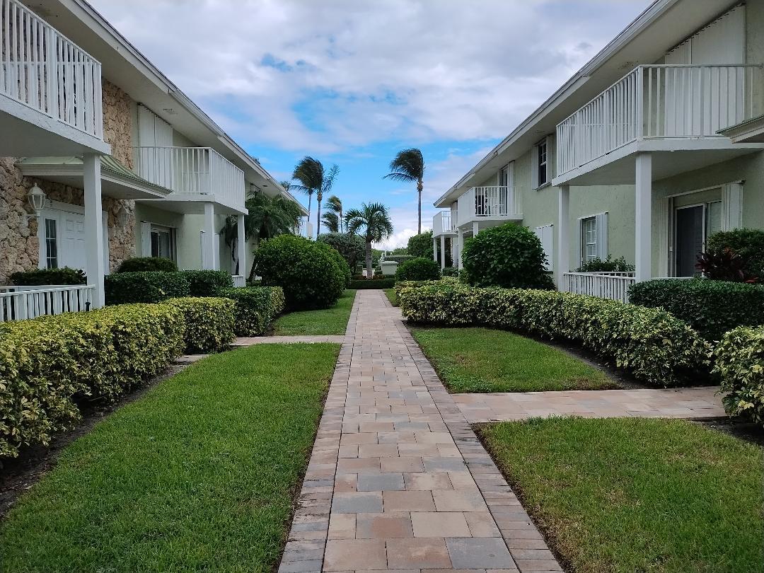 a view of a white house next to a yard