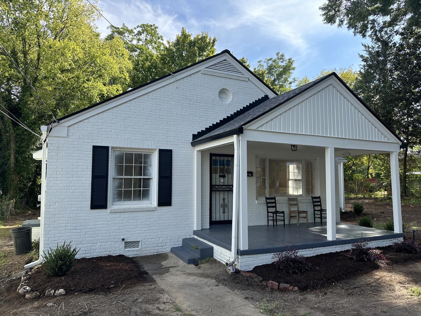 a view of a house with porch and garden