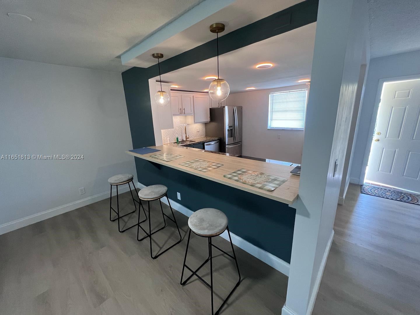 a view of a kitchen area with furniture and wooden floor