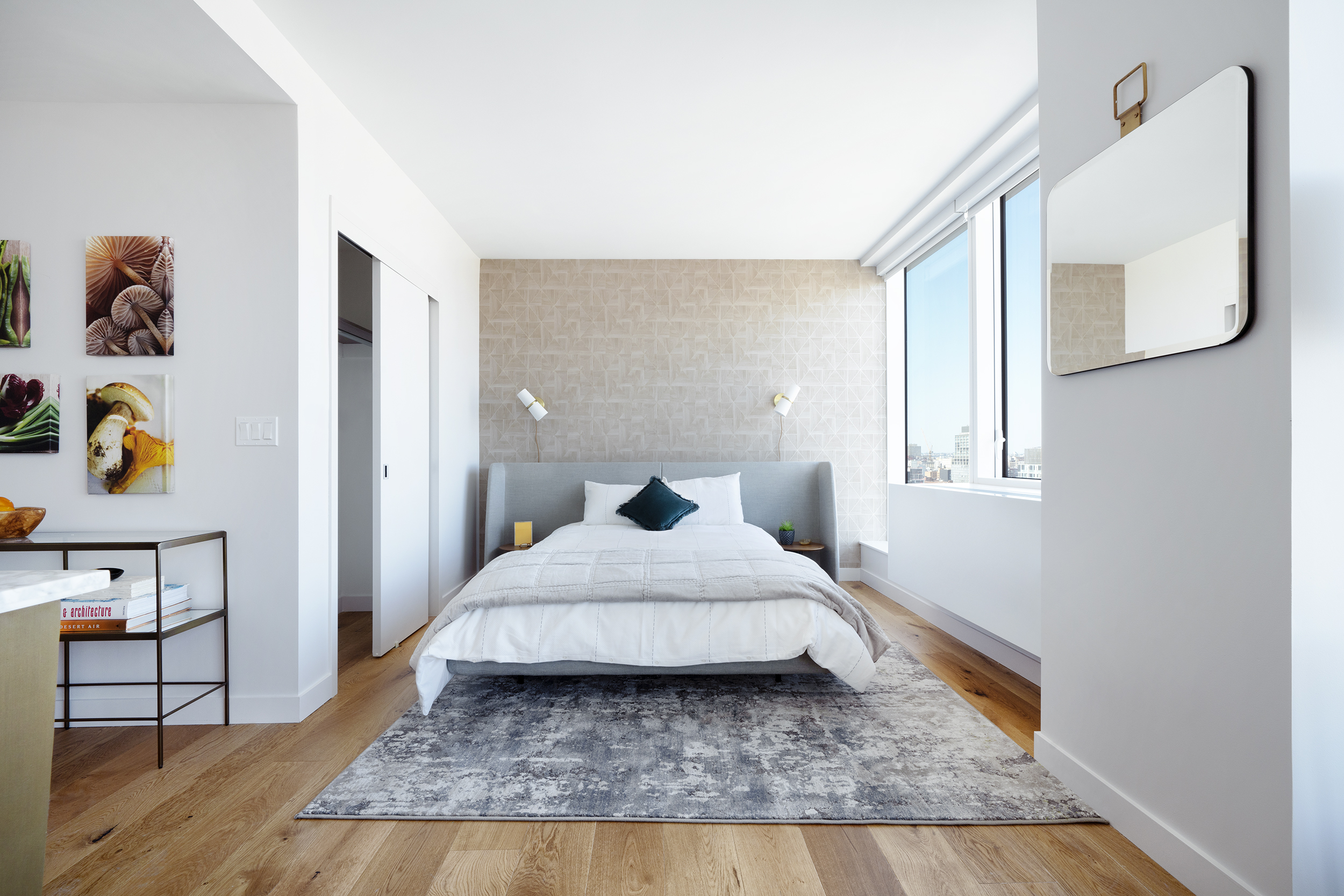 a living room with a bed and dresser with wooden floor