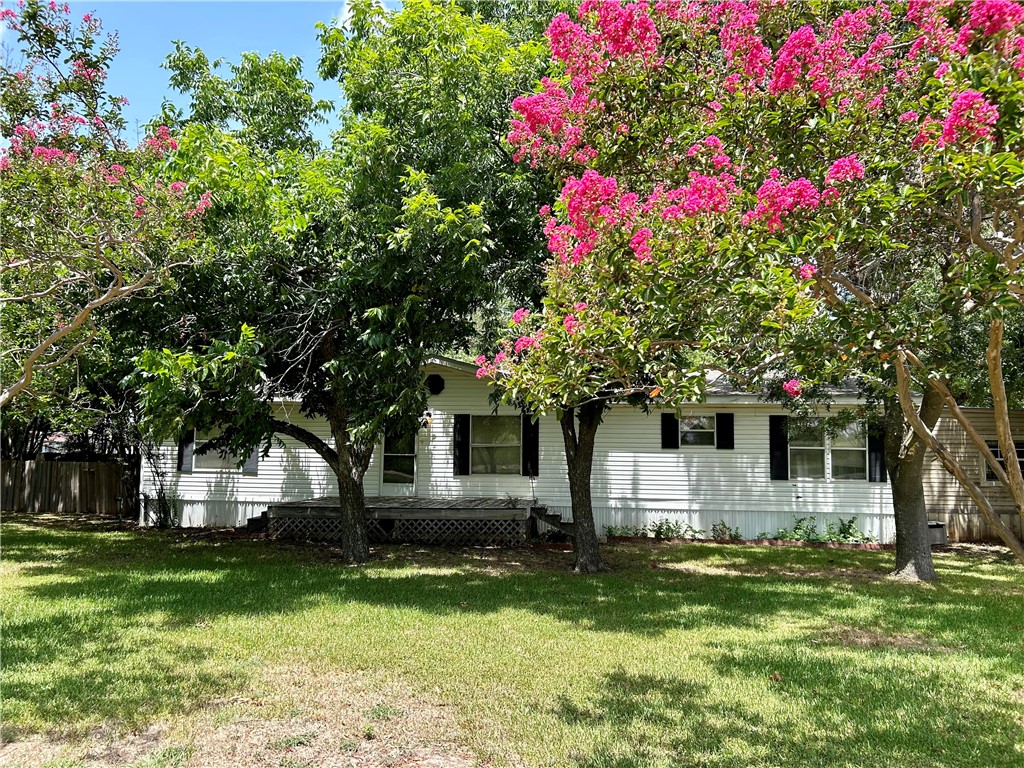 a front view of a house with a yard and tree