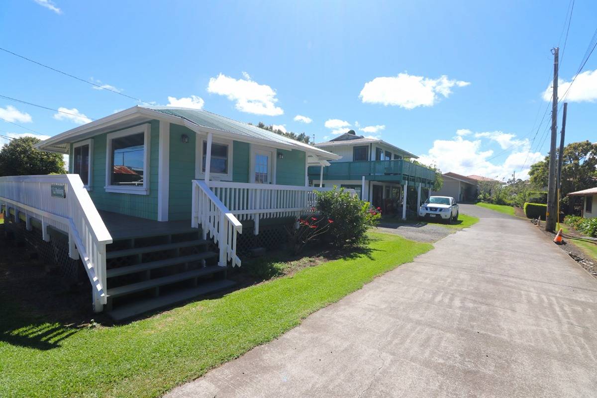 a front view of a house with garden and parking