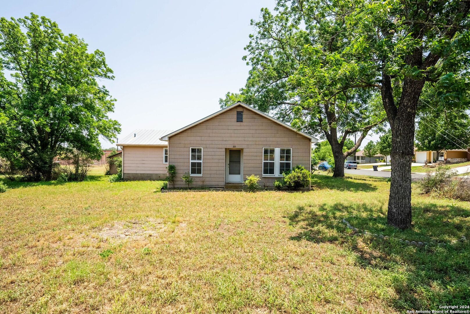 a view of a house with yard and tree