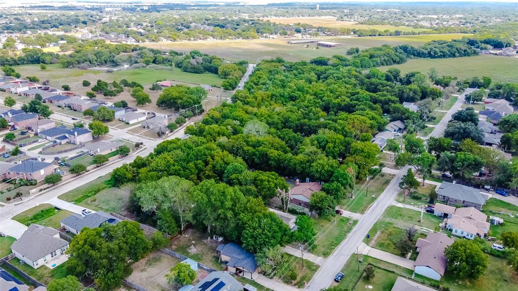 an aerial view of ocean and residential houses with outdoor space