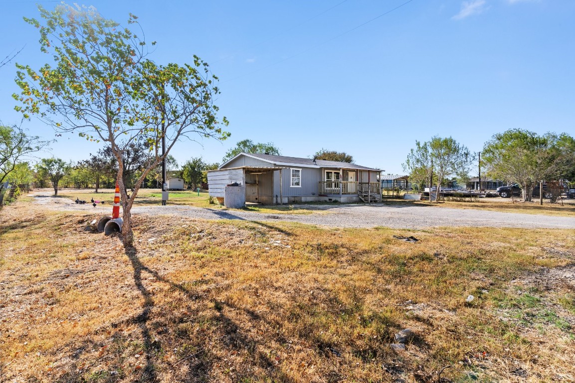 a view of residential houses with yard and road