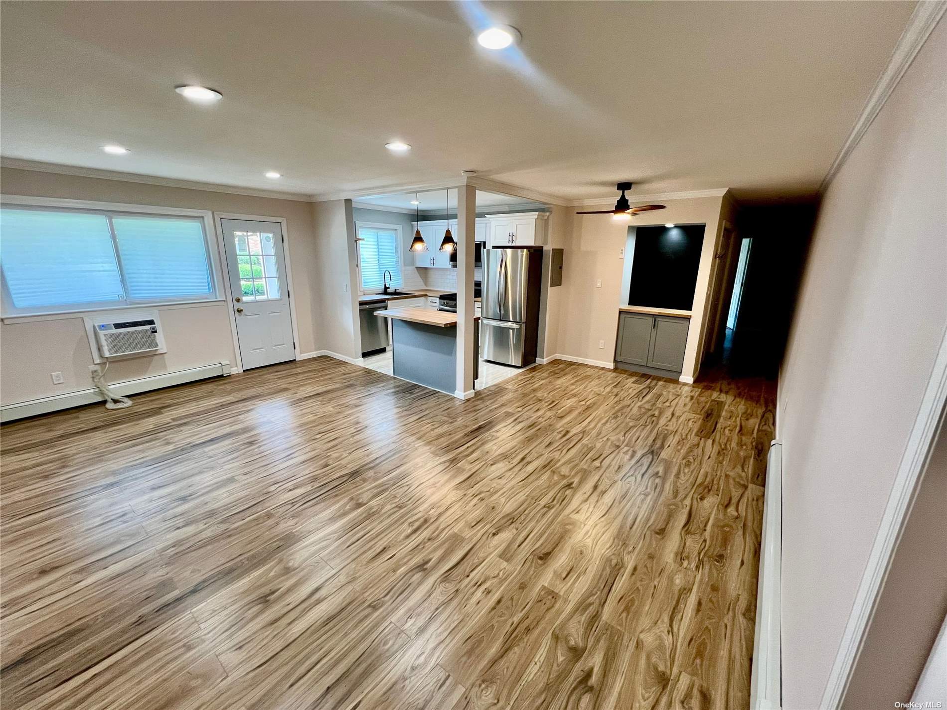 a view of a kitchen with wooden floor and electronic appliances