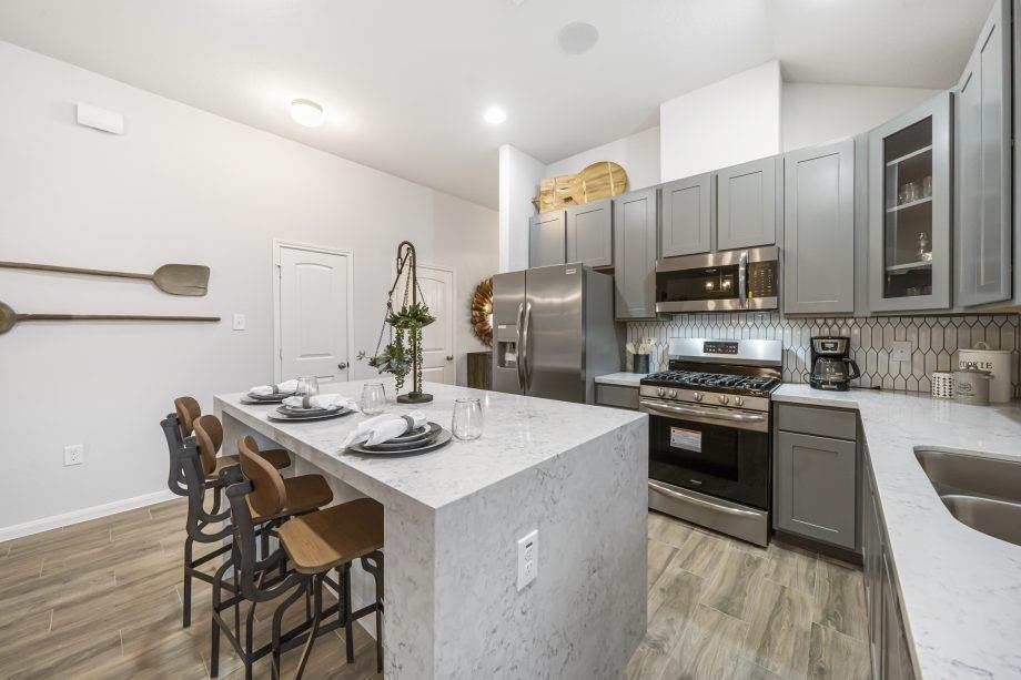 a kitchen with stainless steel appliances granite countertop a kitchen island hardwood floor sink stove and microwave