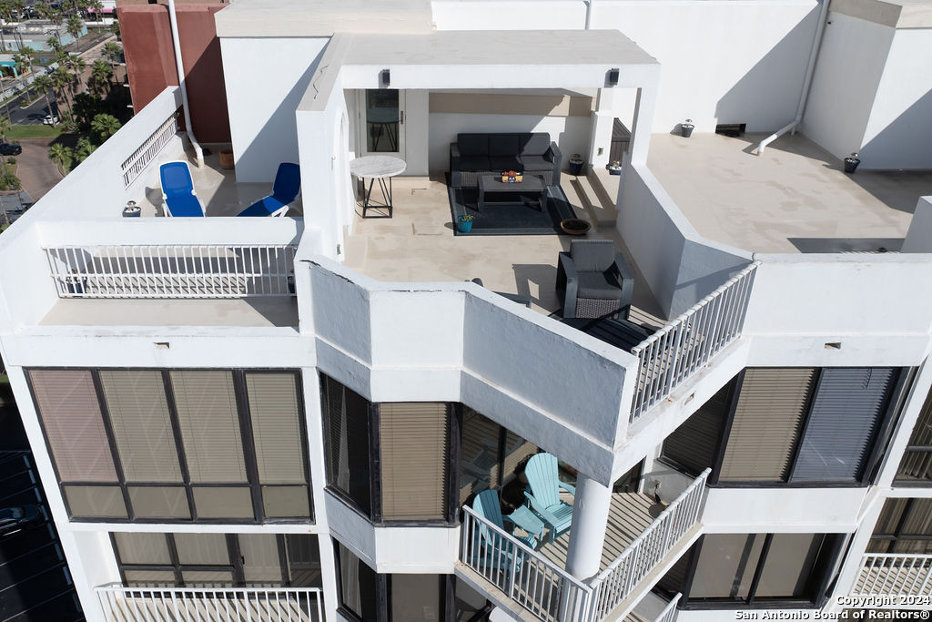 a view of a house with wooden deck stairs and furniture