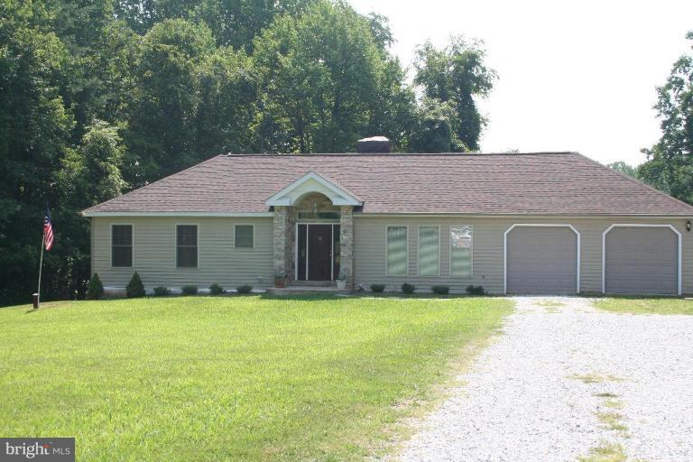 a front view of a house with yard and trees