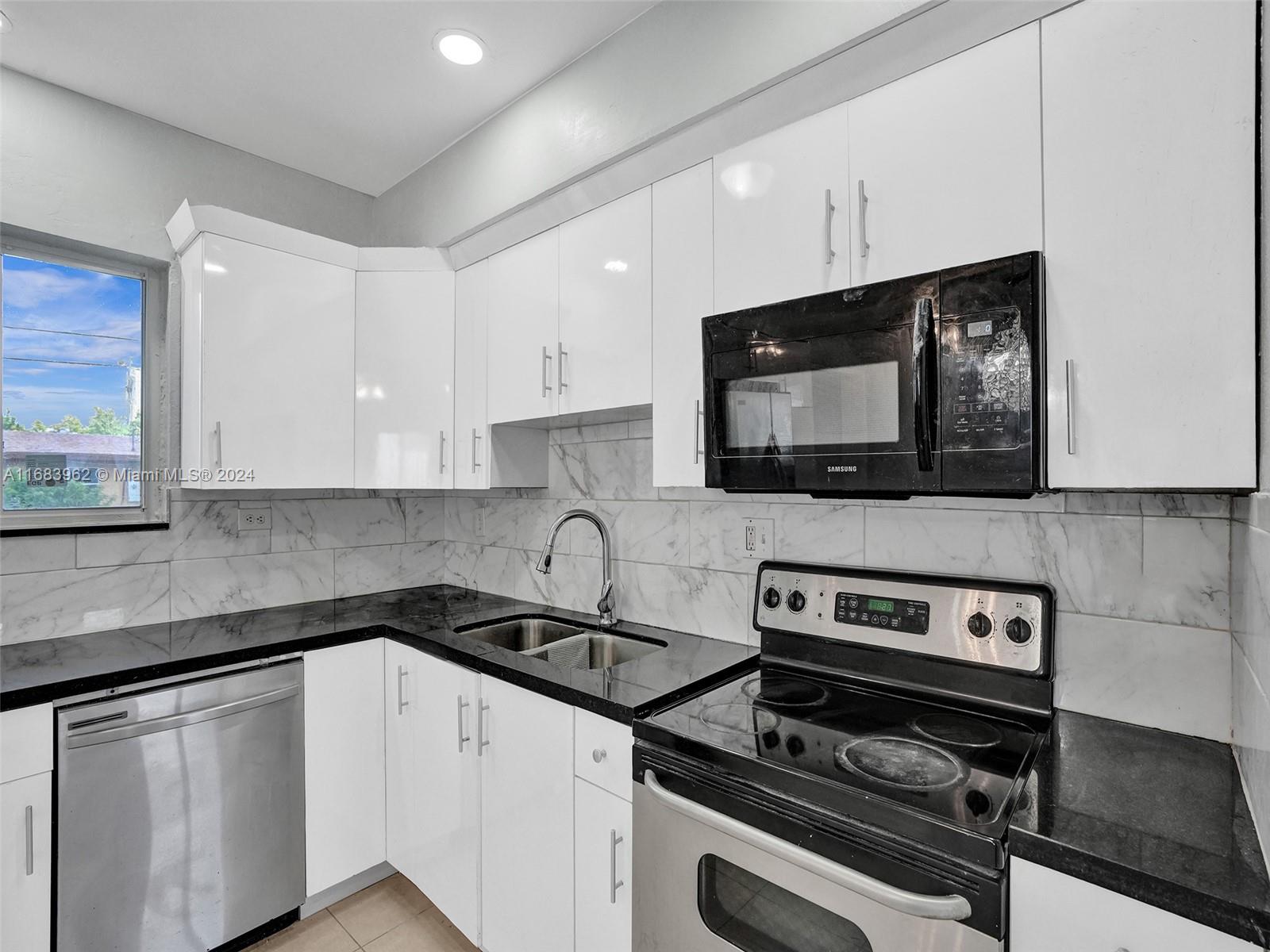 a kitchen with granite countertop a sink and a stove top oven