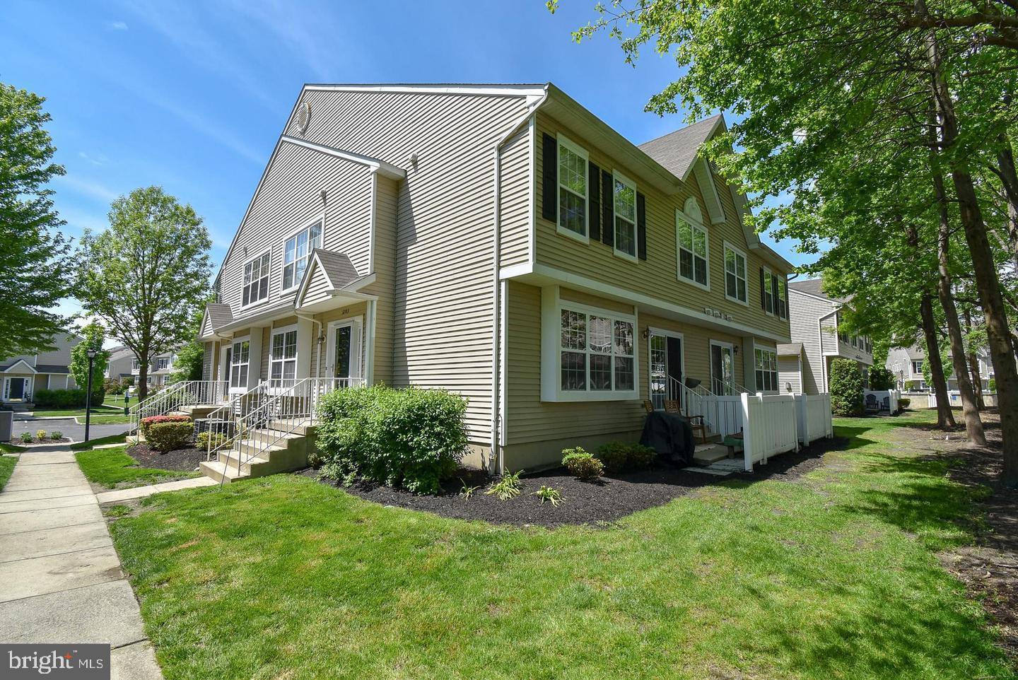 a front view of a house with a yard and trees