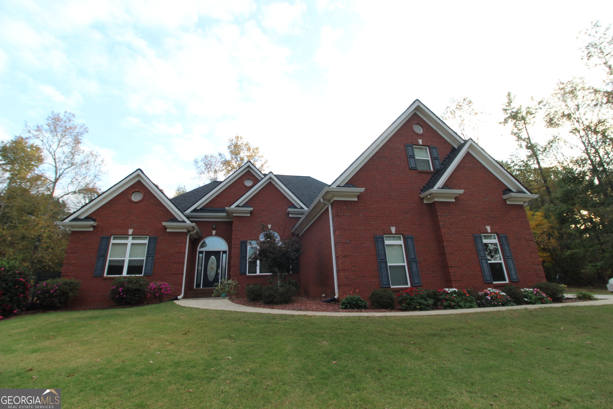 a front view of a house with a garden