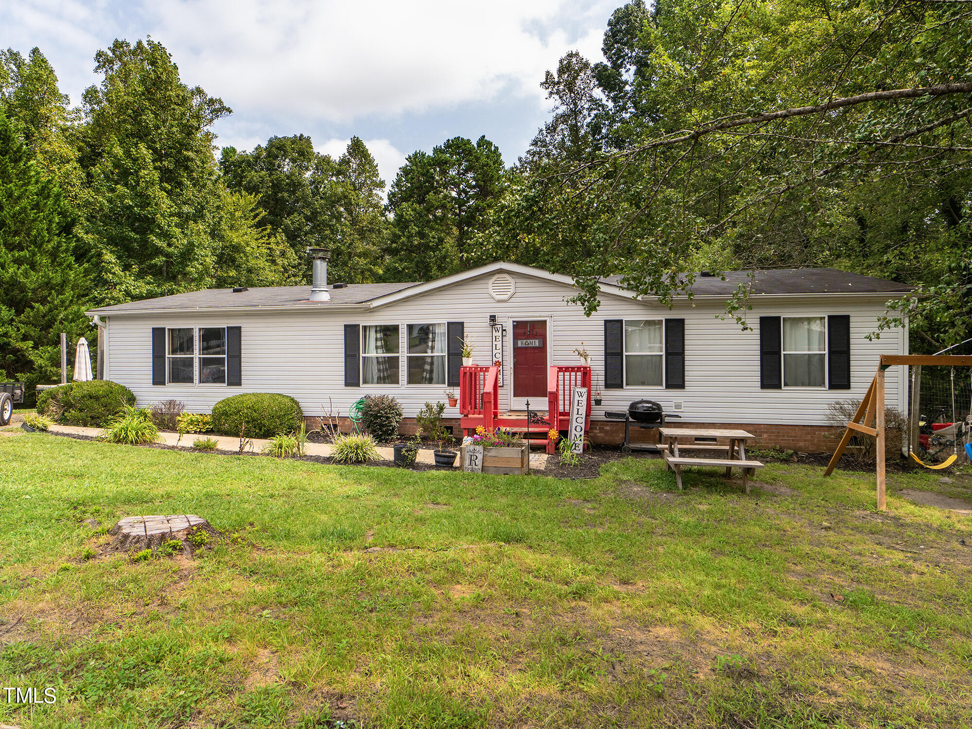 a view of a house with a patio and a yard