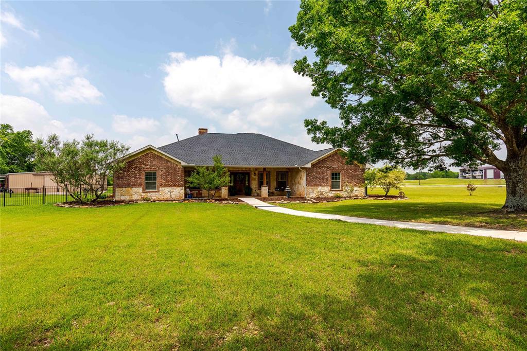 a front view of a house with yard and swimming pool