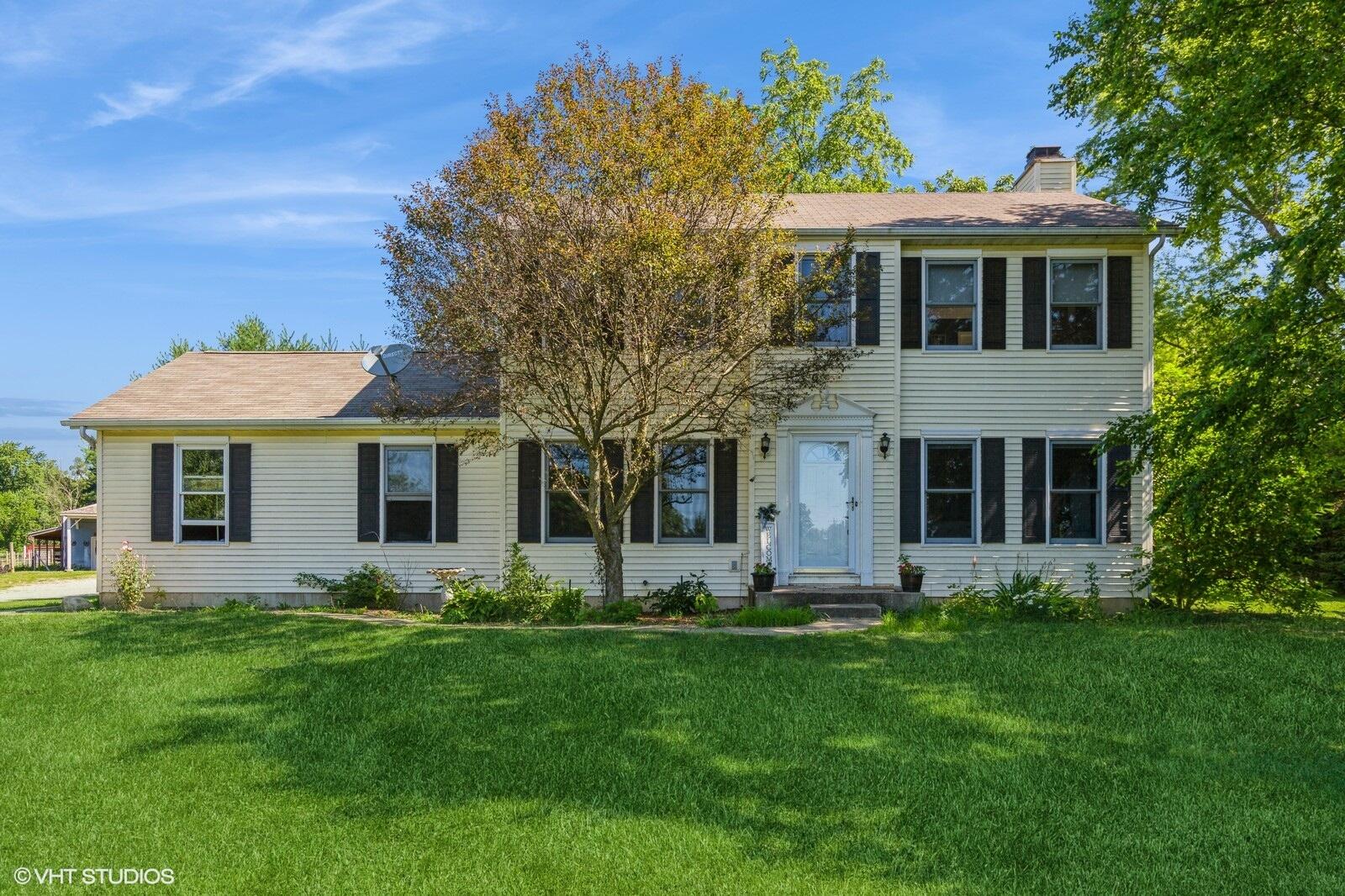 a front view of house with yard and green space