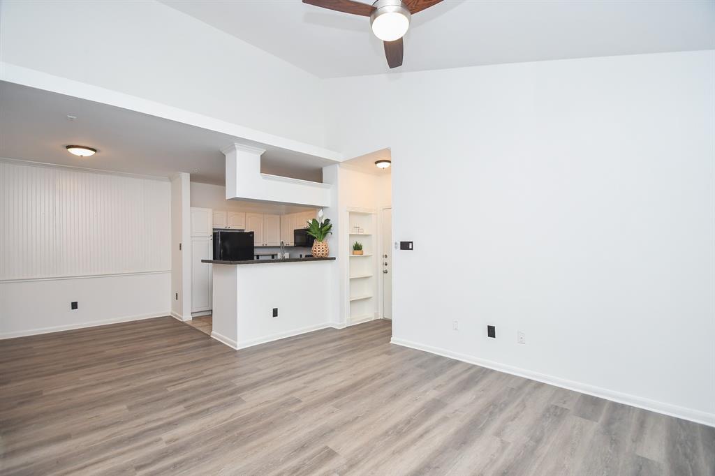 a kitchen with cabinets wooden floor and white appliances