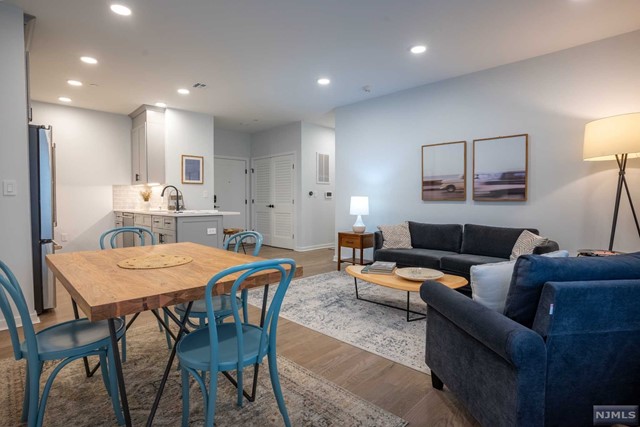 a living room with furniture and a dining table with kitchen view