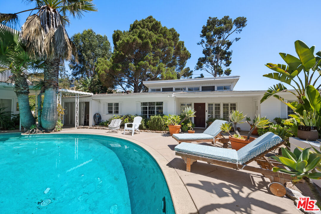 a view of a house with swimming pool and sitting area