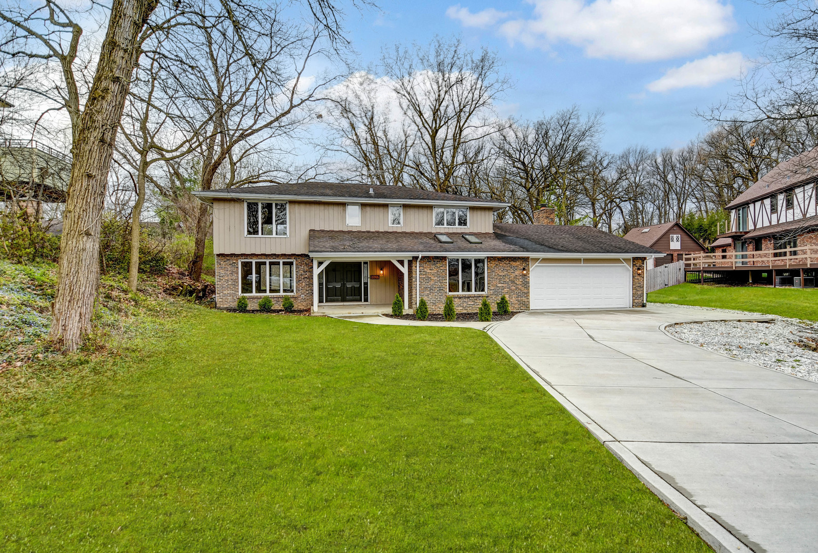 a front view of a house with a garden and trees