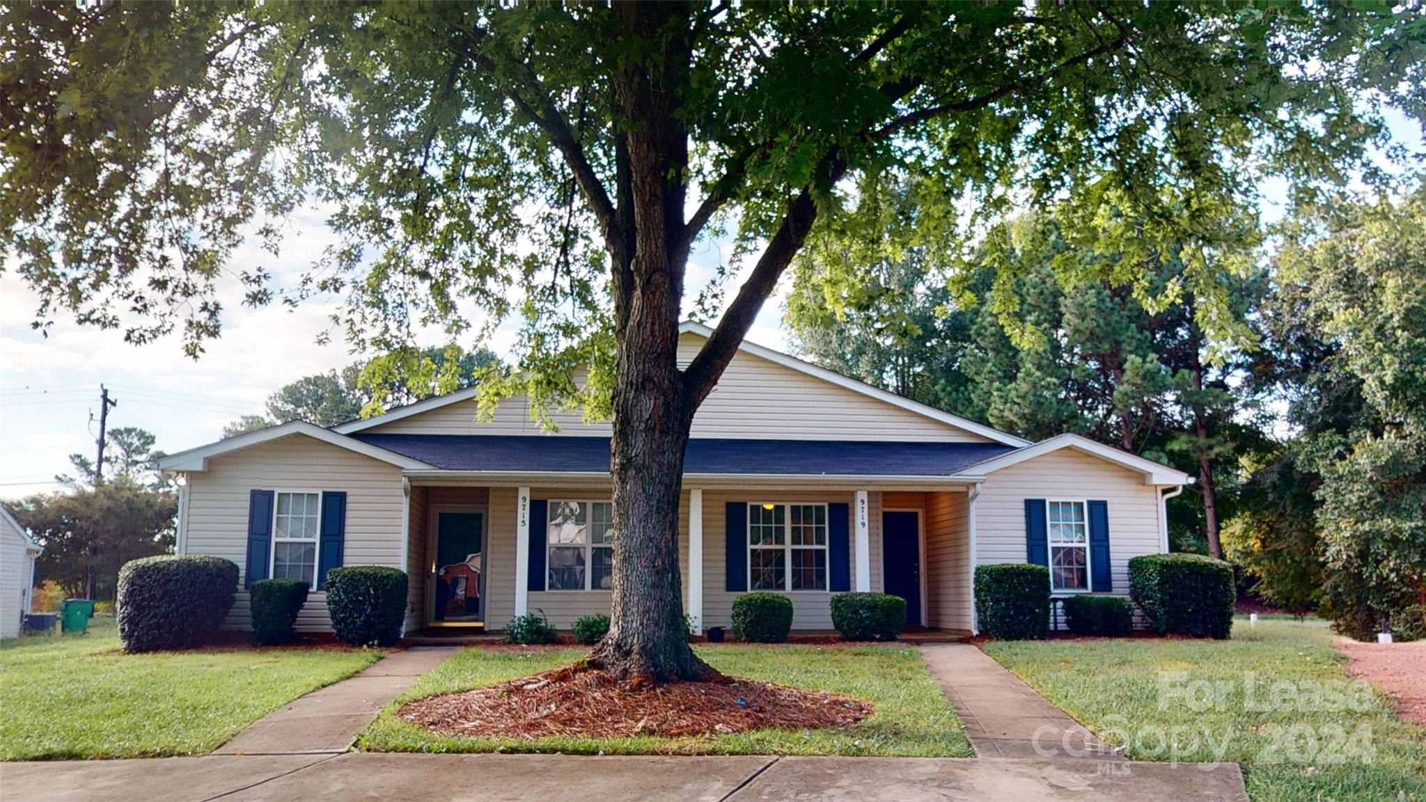 a front view of a house with a yard and trees