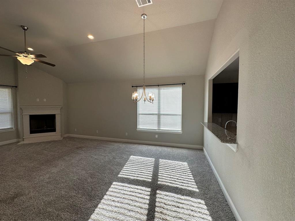 an empty room with windows and fireplace