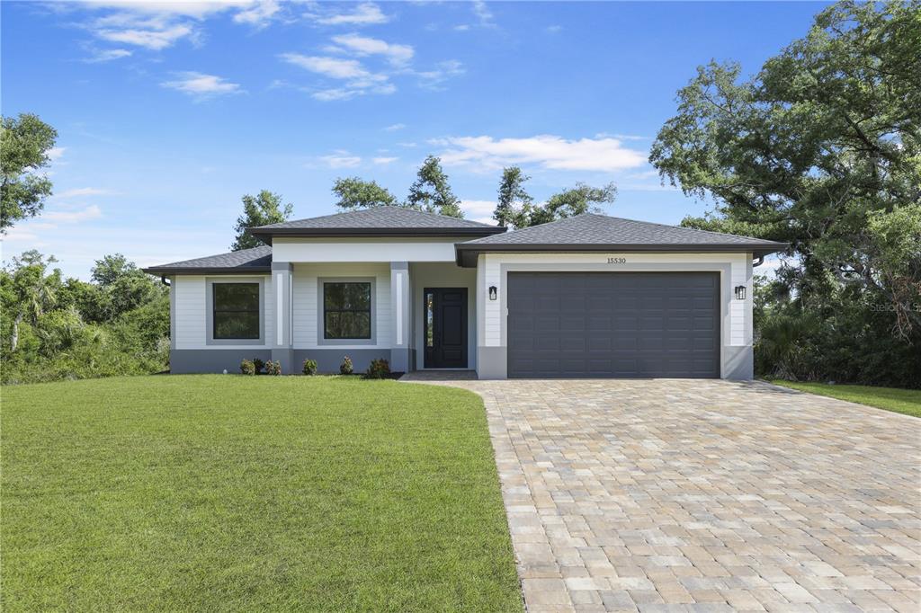 a front view of a house with a yard and garage