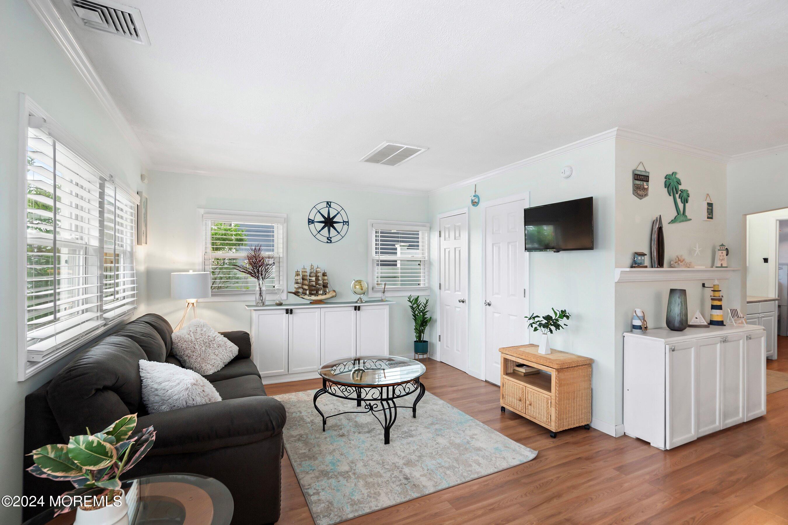 a living room with furniture a flat screen tv and a large window