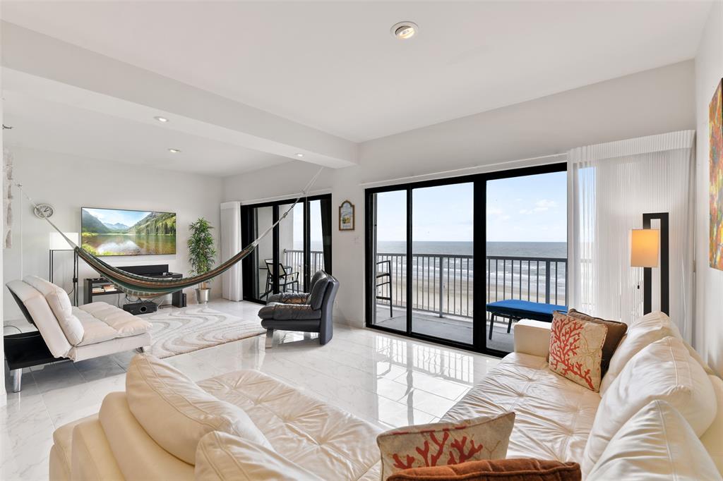 a living room with furniture and floor to ceiling windows