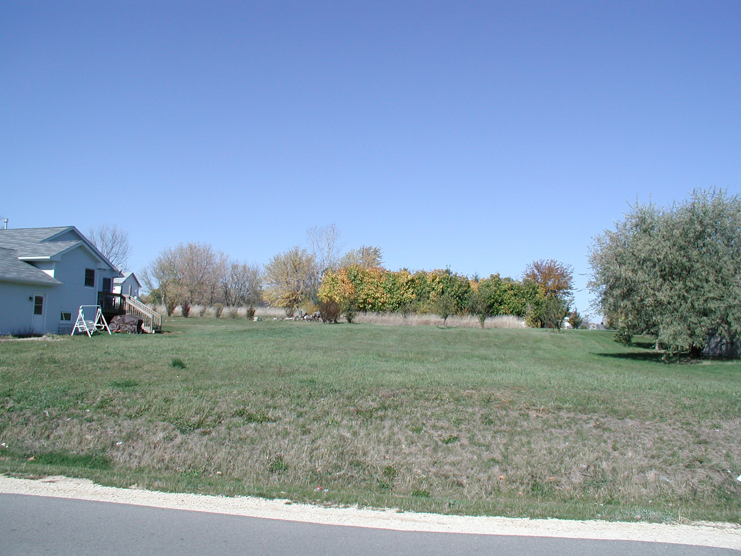 a view of a field with trees in background