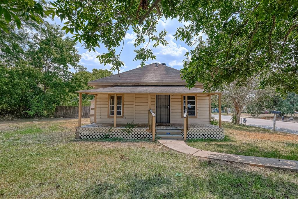 a view of a house with a yard and tree