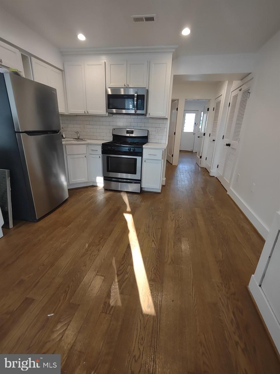 a kitchen with stainless steel appliances a refrigerator and a stove top oven