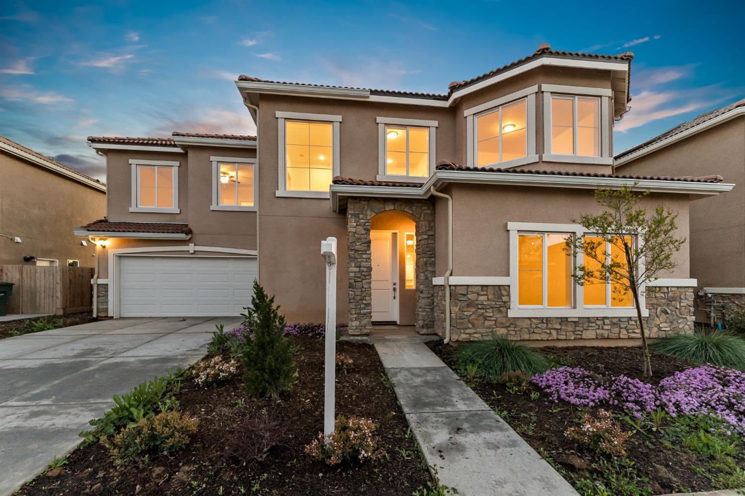 a front view of house and yard with beautiful flowers