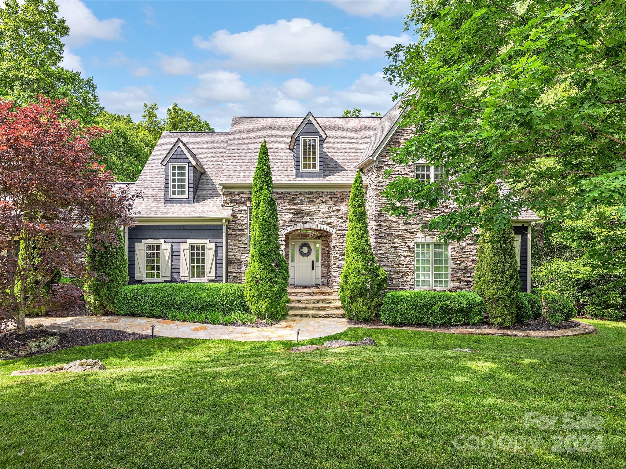 a front view of a house with a garden