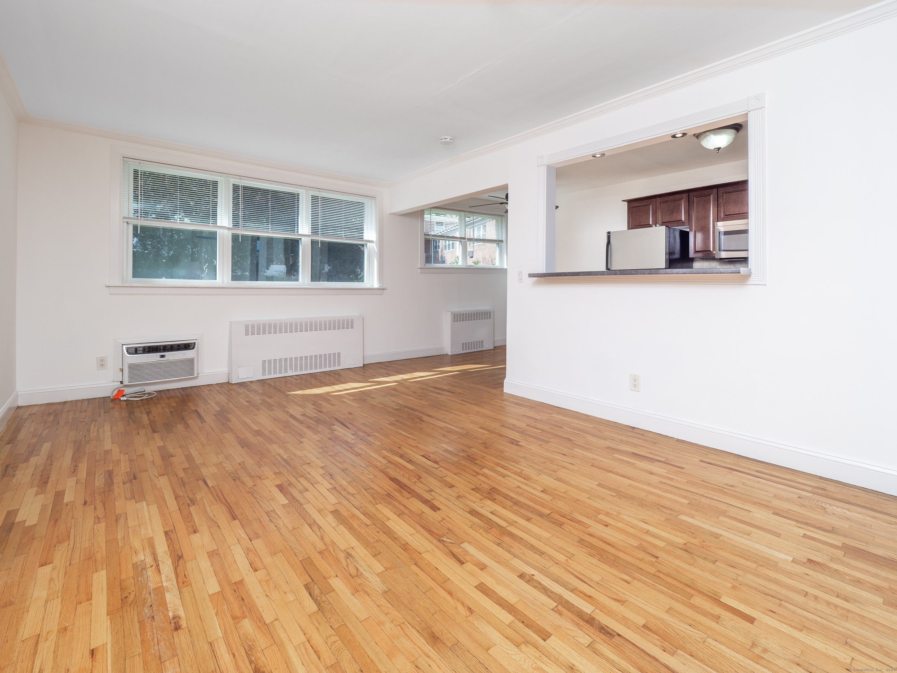 a view of empty room with a window and wooden floor