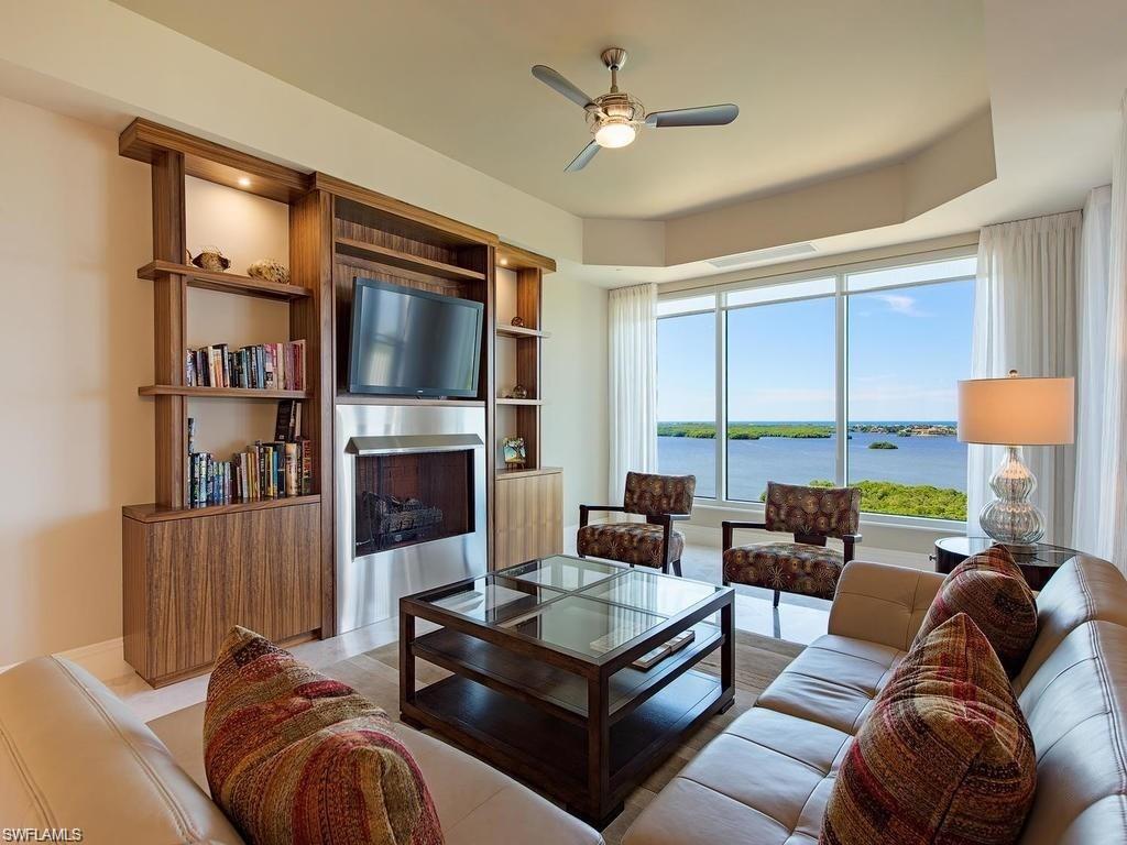 a living room with furniture a flat screen tv and a large window