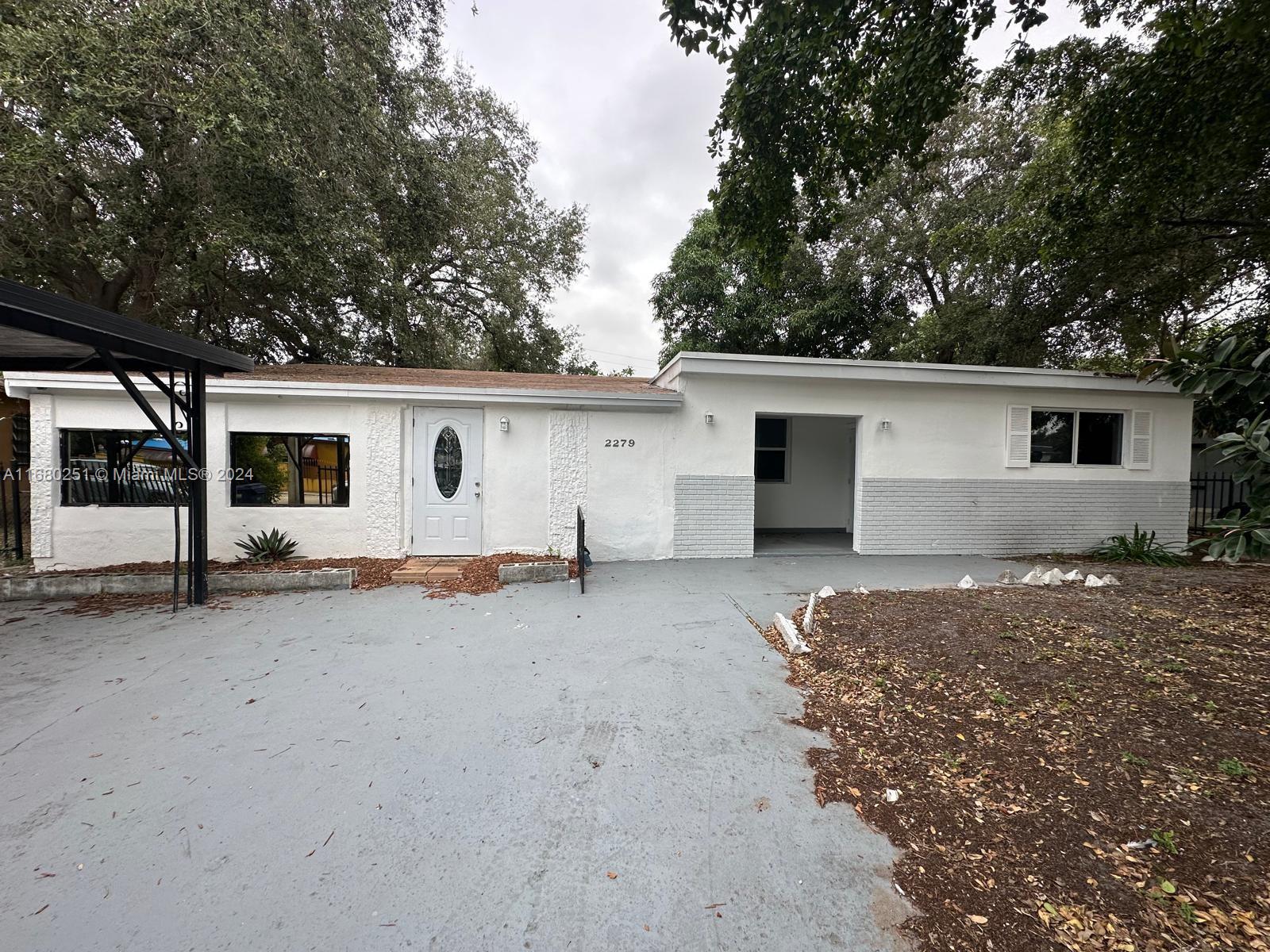 a view of a house with backyard and a tree