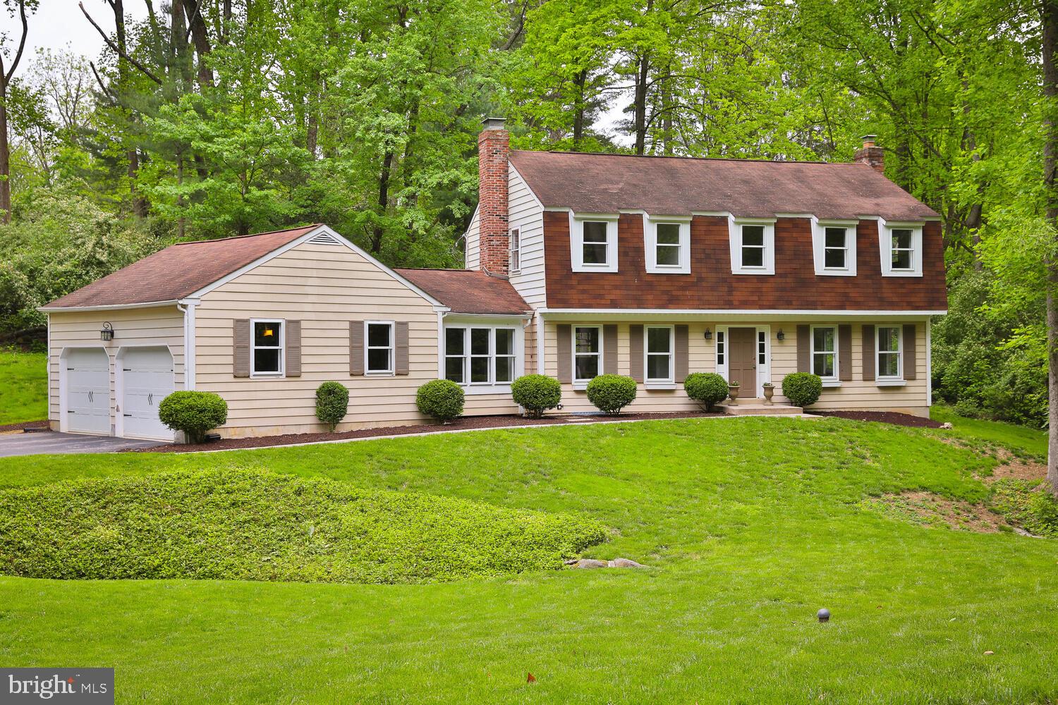 a front view of a house with a yard and green space