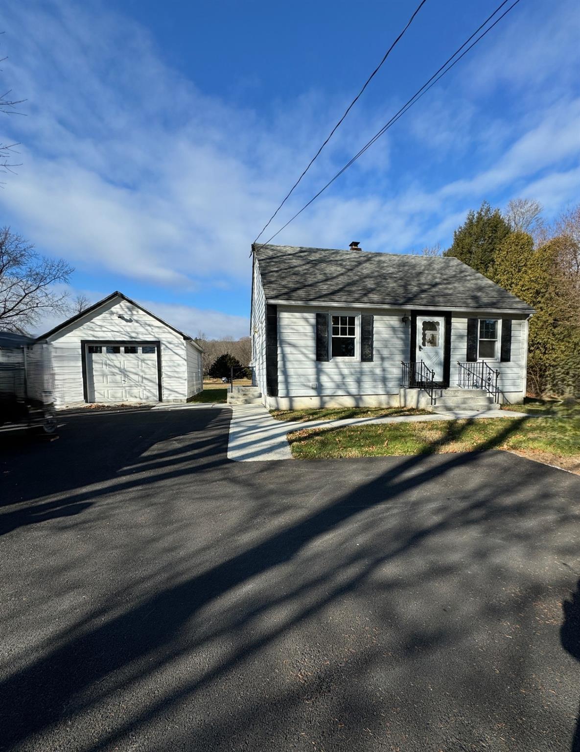 View of front of home featuring a garage and an outdoor structure