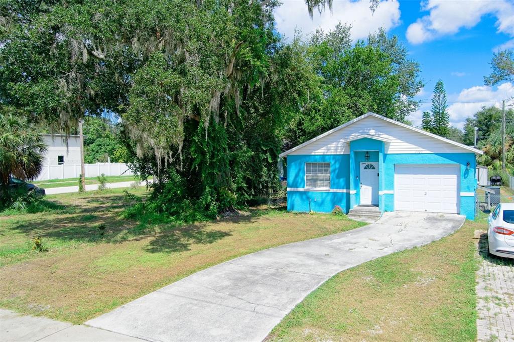 a front view of a house with a yard and trees