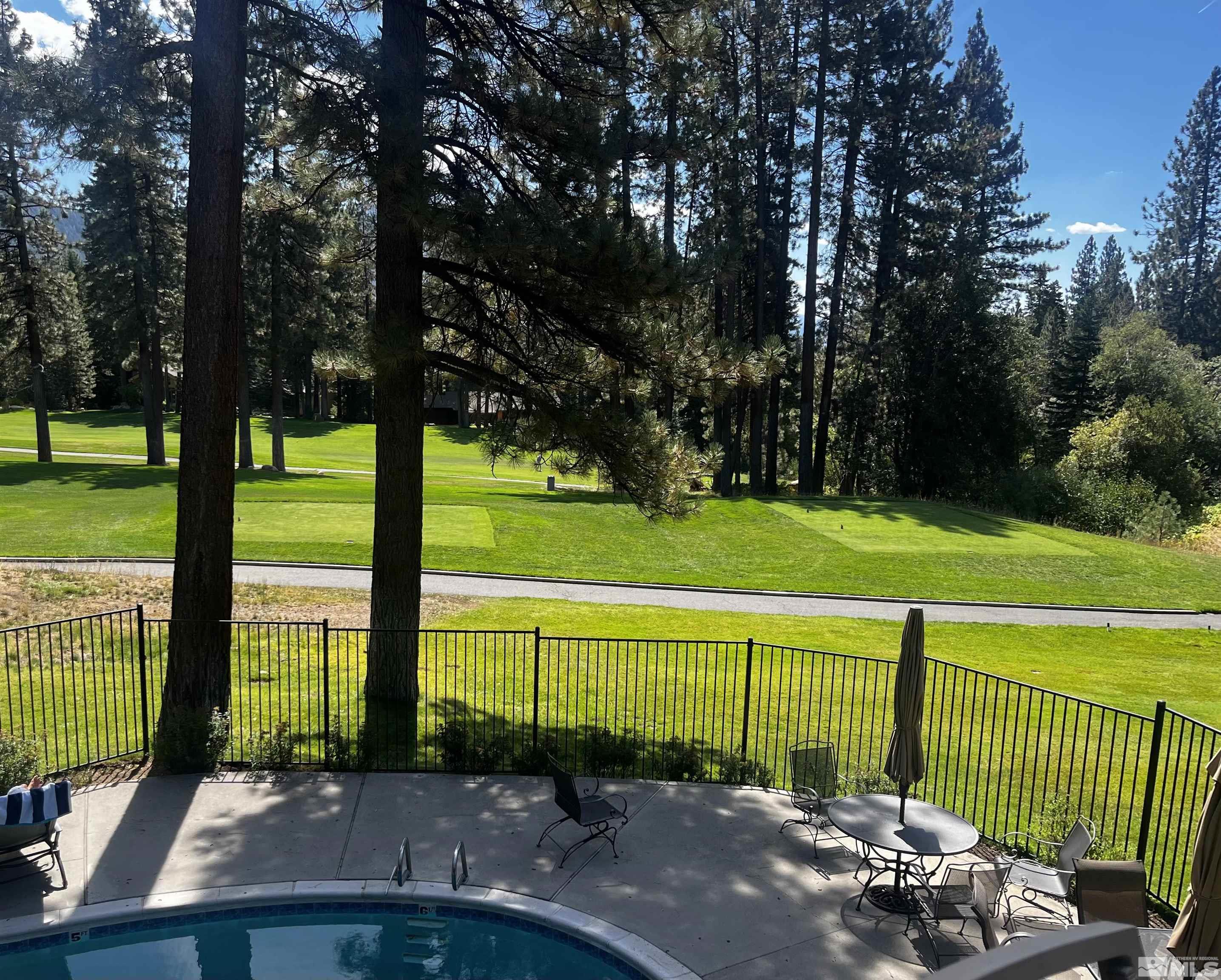 a view of a tennis court with a big yard