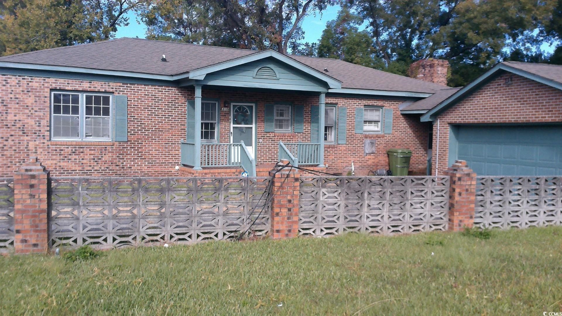 Ranch-style home with a front yard and a garage