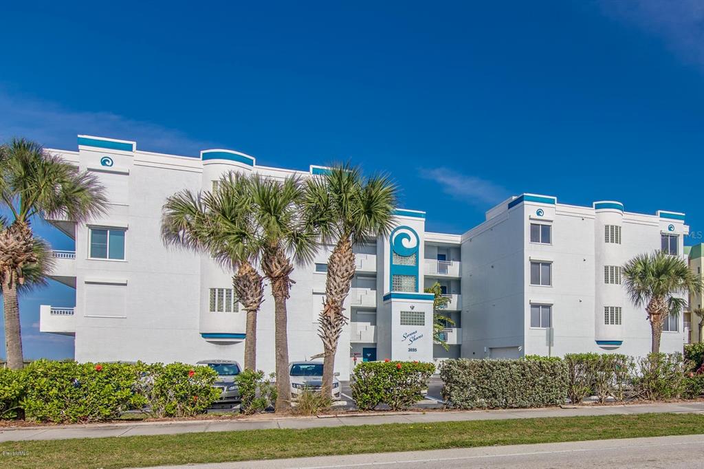 a front view of a multi story building with yard