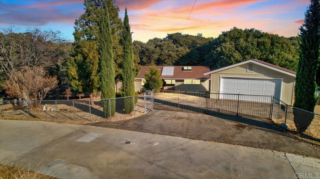 a view of a house with a yard and large tree