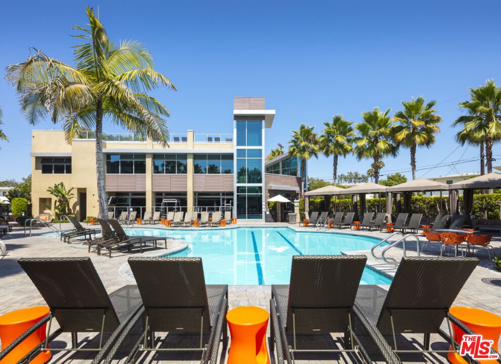 a view of a chairs and table in the patio and a swimming pool