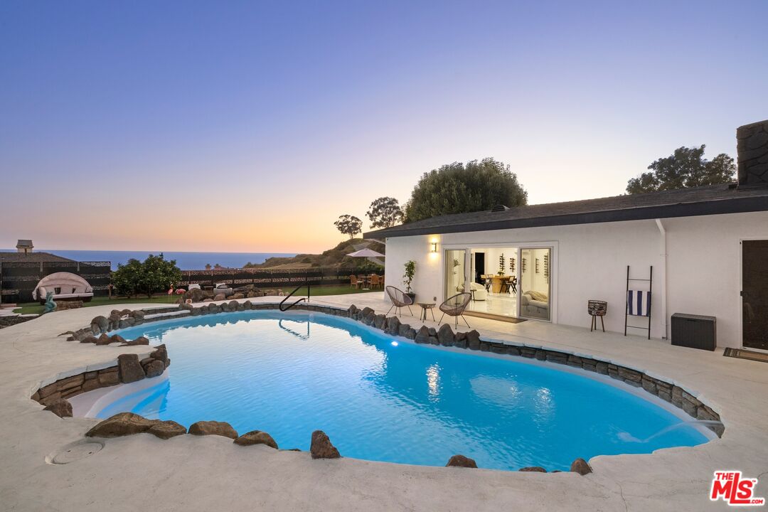 a view of a swimming pool and lounge chairs