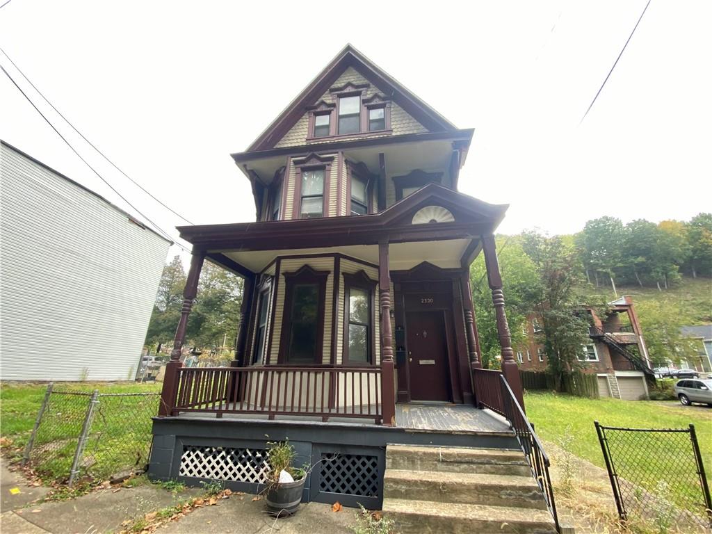 a view of a house with a small yard and wooden fence