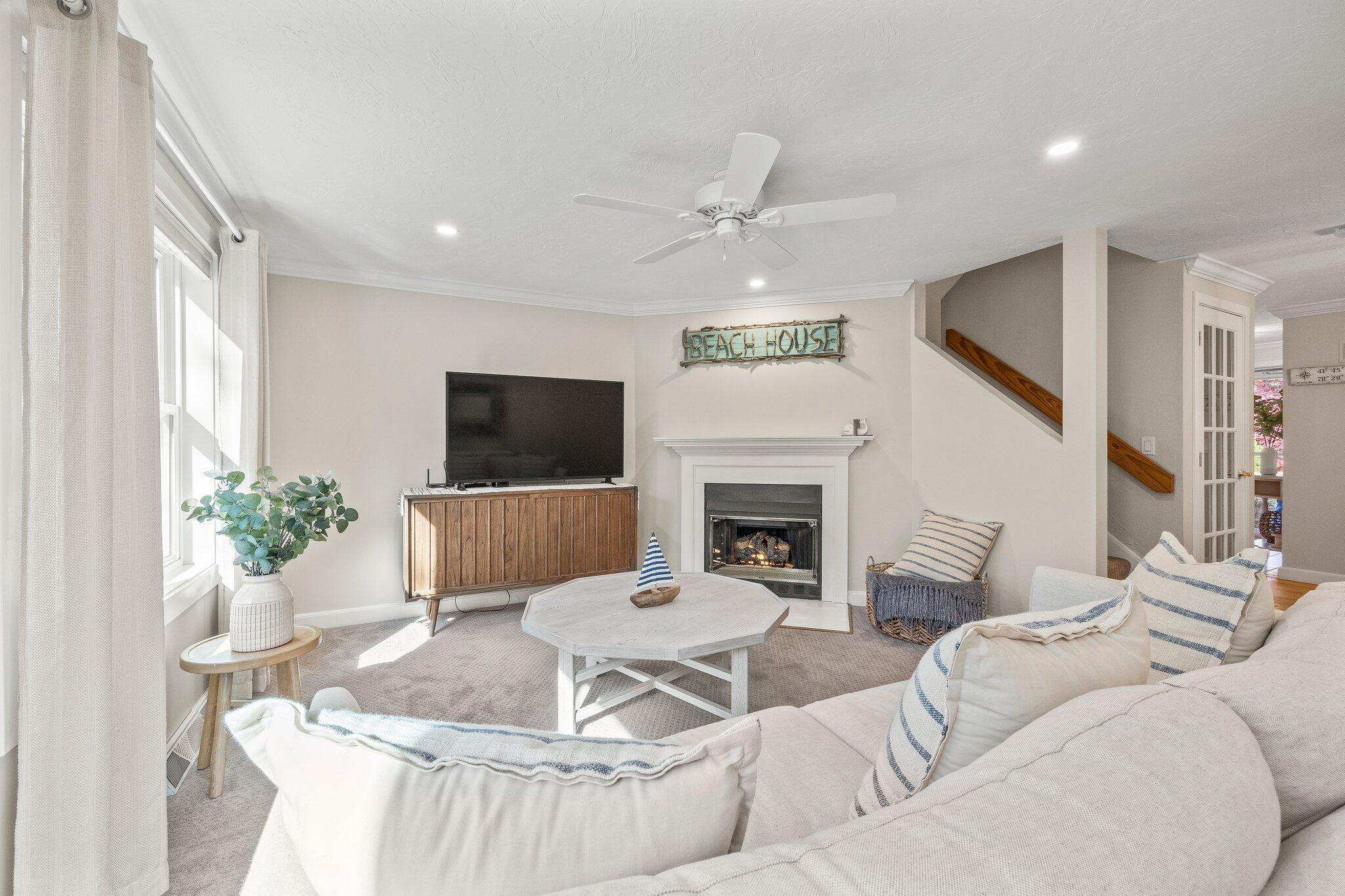 a living room with furniture a flat screen tv and a fireplace