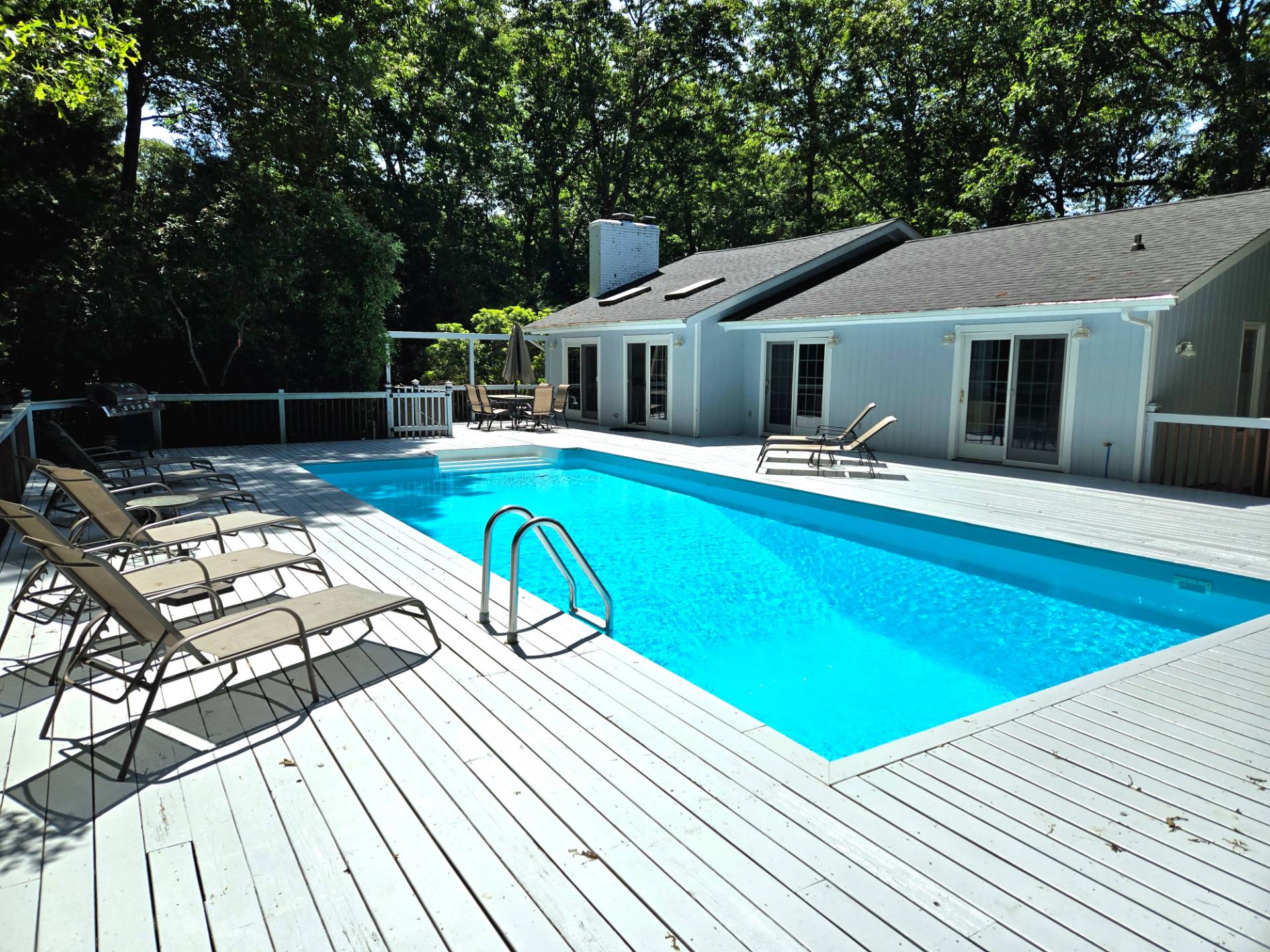 a view of a house with pool and chairs