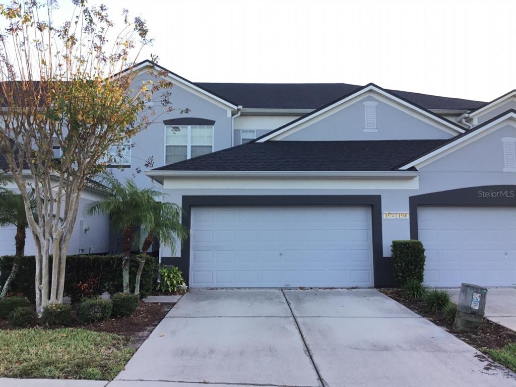 a front view of house with yard and trees in the background